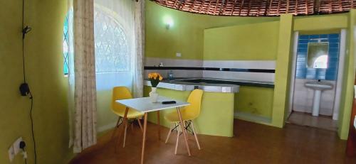 姆特瓦帕Omnia Resort的厨房配有黄色的椅子和一张桌子及水槽