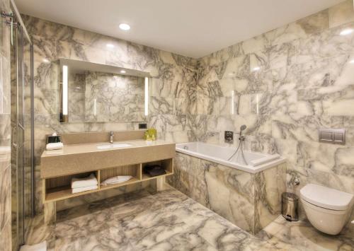 伊斯帕尔Hilton Garden Inn Isparta的一间带水槽、浴缸和卫生间的浴室