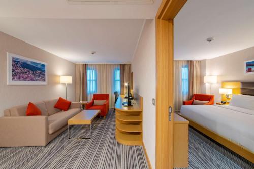 番红花城萨夫兰博卢希尔顿花园酒店的酒店客房,配有床和沙发