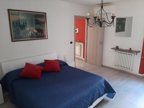 维纳利亚瑞勒House Vittone Venaria Reale的一间卧室配有蓝色的床和两个红色枕头