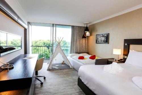 慕尼黑希尔顿慕尼黑公园酒店的酒店客房配有两张床和一张书桌