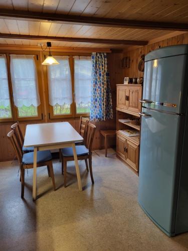 因内特基尔兴Gemütliches Chalet的厨房配有桌子和冰箱