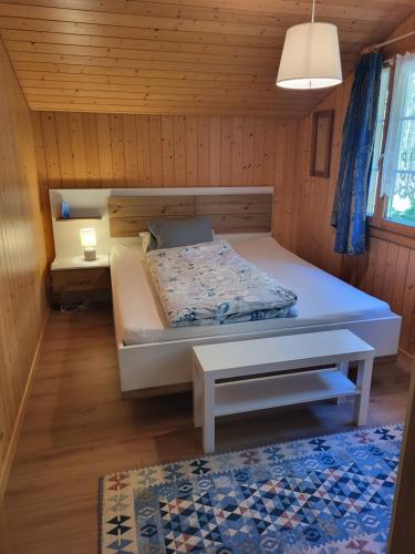 因内特基尔兴Gemütliches Chalet的木制客房内的一间卧室,配有一张床