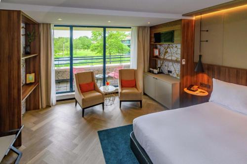 索斯图尼恩DoubleTree by Hilton Royal Parc Soestduinen的酒店客房,配有一张床和两把椅子
