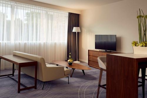 弗罗茨瓦夫弗罗茨瓦夫希尔顿逸林酒店的酒店客房设有一个带电视的起居区。