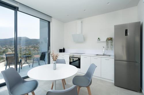 拉夫蒂港White Cliff Luxury Suites by A&D Properties的白色的厨房配有白色的桌子和椅子