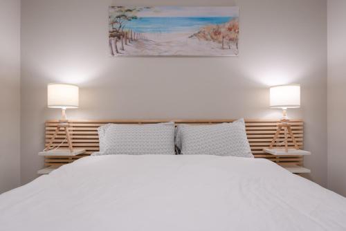 科克伦Modern 3 Bedroom Home & Office & Media Room的一间卧室配有一张带两盏灯的大型白色床。
