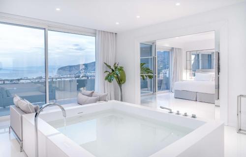 索伦托希尔顿索伦托皇宫酒店的带浴缸的白色浴室和卧室