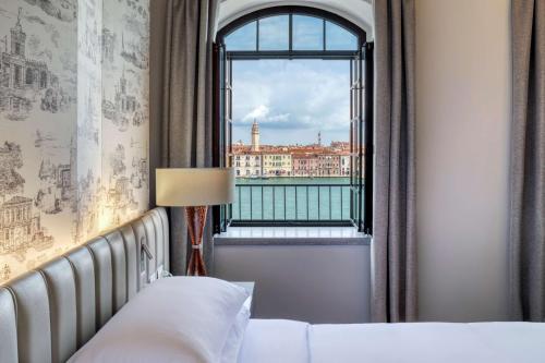 威尼斯威尼斯莫利诺斯塔基希尔顿酒店的一间卧室设有窗户,享有城市美景