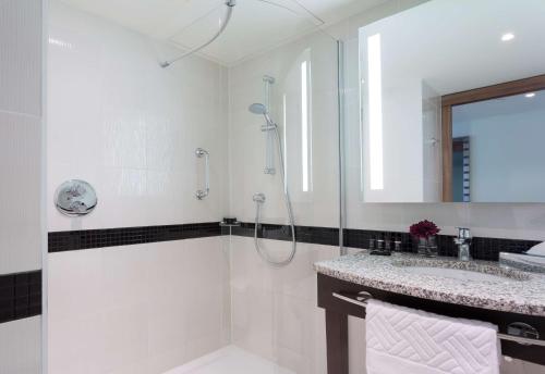 华沙华沙市中心希尔顿汉普顿酒店的带淋浴和盥洗盆的白色浴室