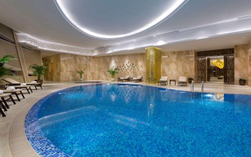 阿斯塔纳阿斯塔纳希尔顿酒店的在酒店房间的一个大型游泳池