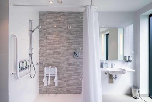 华沙汉普顿希尔顿华沙莫克托酒店 的带淋浴和盥洗盆的浴室