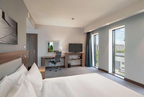 华沙汉普顿希尔顿华沙莫克托酒店 的酒店客房设有一张床、一张书桌和一台电视机。