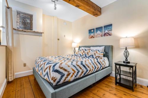 斯托Stowe Mountain Road Escape的一间卧室配有一张床和一张桌子上的台灯