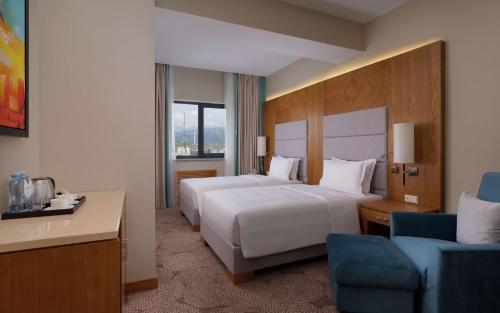 阿拉木图DoubleTree by Hilton Almaty的酒店客房,配有两张床和椅子