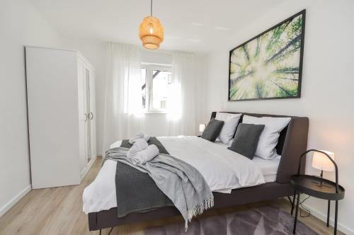 比勒费尔德Großzügig & individuell - Balkon - WiFi - TV的卧室配有一张带白色墙壁的大床