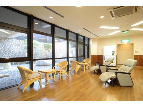 OtsukiHotel Bellreef Otsuki - Vacation STAY 43775v的一间设有桌椅和窗户的等候室