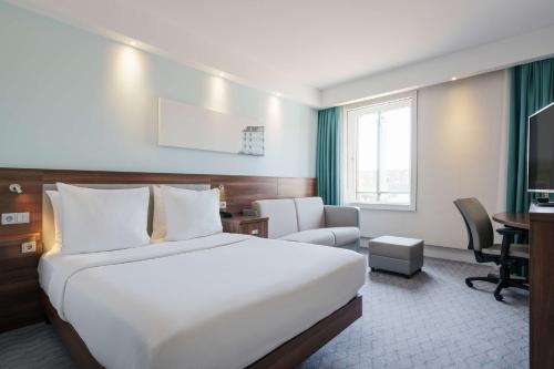 阿姆斯特丹阿姆斯特丹中心东部汉普顿希尔顿酒店的酒店客房设有一张大床和一张书桌。