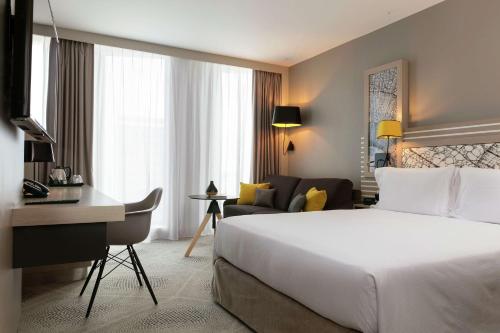 波尔多波尔多市中心希尔顿花园酒店的配有一张床和一张书桌的酒店客房
