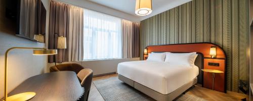 布鲁塞尔DoubleTree By Hilton Brussels City的配有一张床和一张书桌的酒店客房