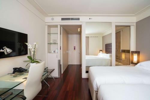 佛罗伦萨希尔顿佛罗伦萨大都市酒店的酒店客房配有书桌和床。