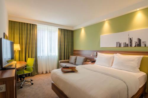 美因河畔法兰克福Hampton by Hilton Frankfurt City Centre的酒店客房设有一张大床和一张书桌。