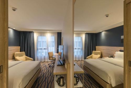 美因河畔法兰克福Hampton By Hilton Frankfurt Airport的酒店客房设有两张床和电视。