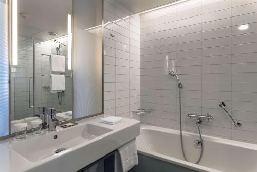 万塔赫尔辛基机场希尔顿酒店的一间带水槽、浴缸和淋浴的浴室