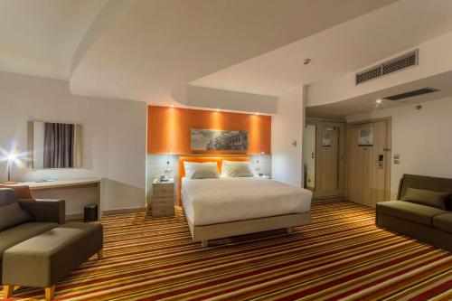 雅西欧罗巴酒店的一间卧室配有一张床、一张沙发和一把椅子