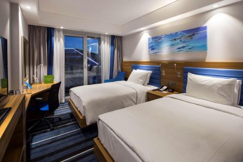 伊斯坦布尔伊斯坦布尔库尔特科伊希尔顿汉普顿酒店的酒店客房配有两张床和一张书桌