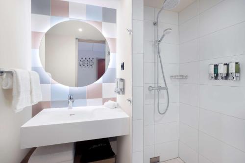 凯撒斯劳滕Hampton By Hilton Kaiserslautern的白色的浴室设有水槽和淋浴。
