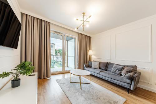 卢布林Aparthotel Plac Litewski Premium的客厅配有沙发和桌子