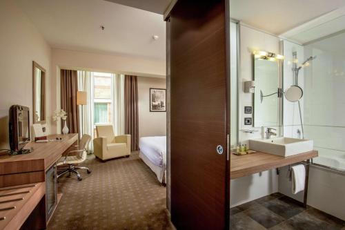 米兰米兰希尔顿酒店集团的酒店客房设有水槽和一间卧室