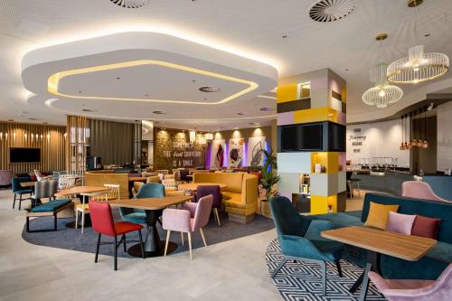 里加Hampton by Hilton Riga Airport的一间带桌椅的餐厅和一间酒吧