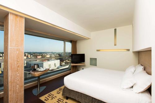罗马罗马克拉里奇希尔顿花园酒店的卧室设有白色的床和大窗户
