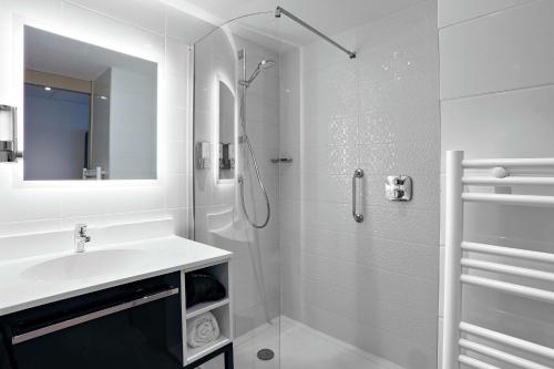 布拉尼亚克Hampton By Hilton Toulouse Airport的白色的浴室设有水槽和淋浴。