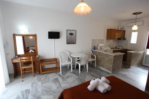 帕拉利亚潘塔利莫诺斯阿空提科德里亚尼公寓的厨房以及带桌椅的起居室。