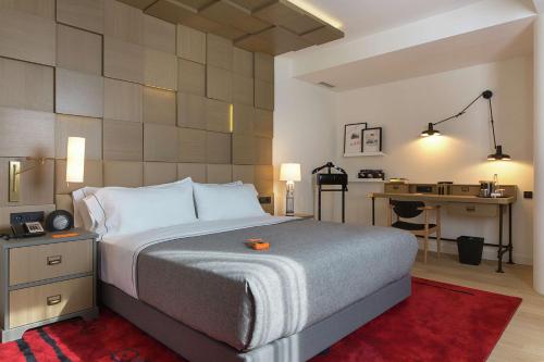 萨格勒布Canopy by Hilton Zagreb City Centre的一间卧室配有一张带书桌和一张书桌的床。