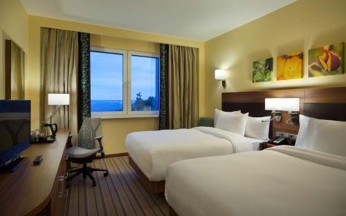 乌法乌法滨江希尔顿花园酒店的酒店客房配有两张床和一张书桌