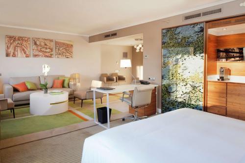 巴塞罗那希尔顿巴塞罗那酒店的一间卧室设有一张床和一间客厅。
