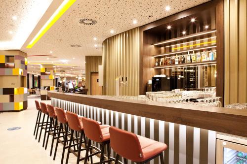 哈尔伯格摩斯Hampton by Hilton Munich Airport South的餐厅酒吧的一排椅子