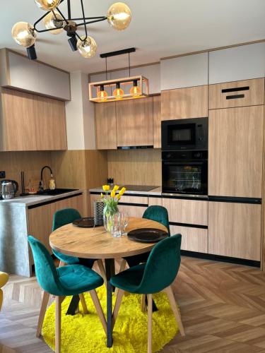 库特诺Apartament Perła Kutna的厨房配有木桌和绿色椅子