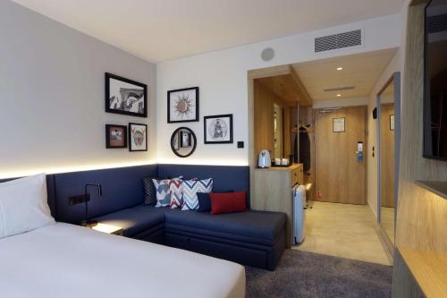 奥尔什丁Hampton By Hilton Olsztyn的一间卧室配有蓝色的沙发和一张床