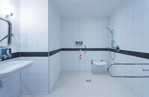 沃罗涅什沃罗涅日希尔顿汉普顿酒店的带淋浴和盥洗盆的白色浴室