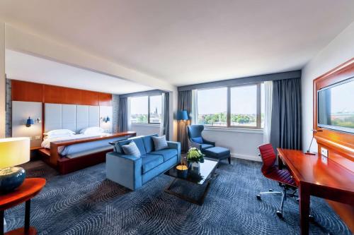 斯特拉斯堡希尔顿斯塔伯格酒店的酒店客房,配有床和蓝色的沙发