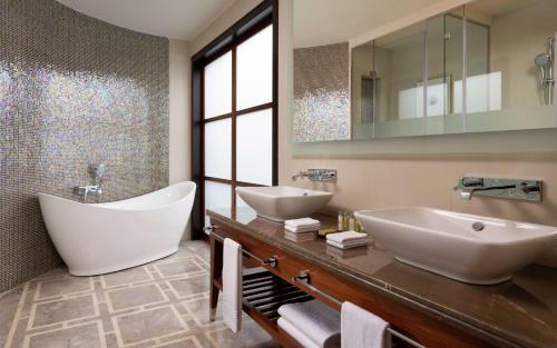 杜尚别Hilton Dushanbe的浴室设有2个水槽、浴缸和镜子