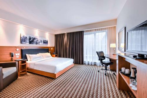 华沙华沙机场汉普顿希尔顿酒店的酒店客房配有一张床、一张书桌和一台电视。