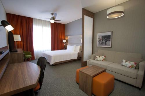 锡劳锡劳机场希尔顿惠庭套房酒店的酒店客房设有床和客厅。