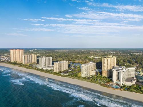 默特尔比奇Embassy Suites by Hilton Myrtle Beach Oceanfront Resort的享有海滩和建筑的空中景致