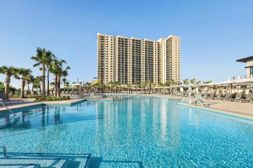 默特尔比奇Embassy Suites by Hilton Myrtle Beach Oceanfront Resort的大型建筑前的大型游泳池